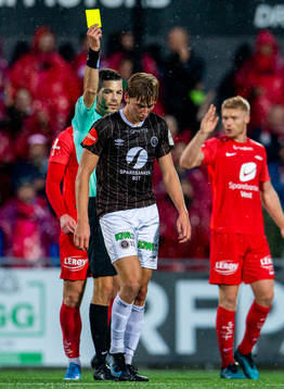 Albin Sporrong of Mjøndalen gets a yellow card from