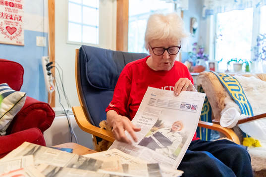 Ingrid Holmgren, f.d fotbollsdomare, visar en tidningssida