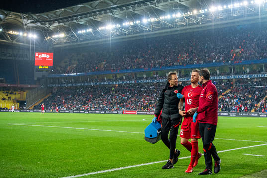 Serdar Aziz of Turkey walks off the pitch with an injury