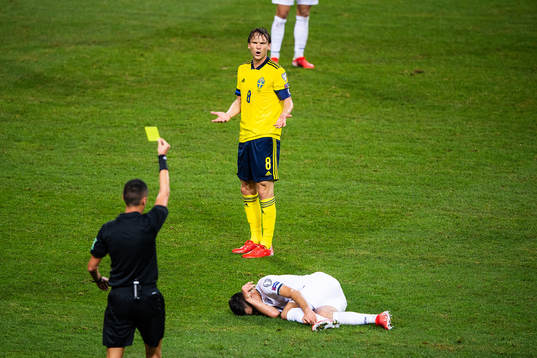 Albin Ekdal of Sweden is shown a yellow card by referee