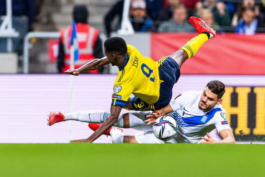 Alexander Isak of Sweden is tackled byKonstantinos