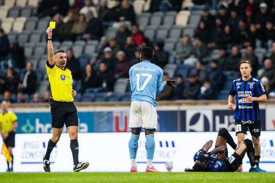 Malmös Malik Abubakari får gult kort av domare Bojan