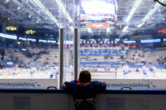 En fanbärare tittar på värmningen före ishockeymatchen