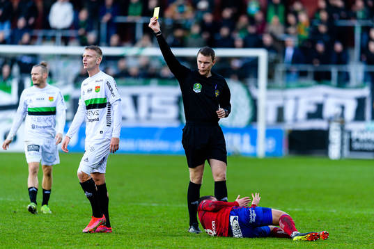 Domare Oscar Johnson delar ut ett gult kort till GAIS