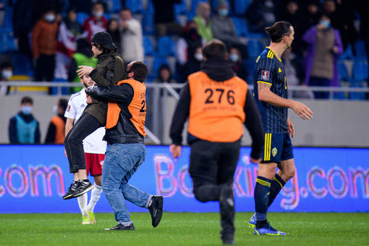 A pitch invader next to Zlatan Ibrahimovic of Sweden