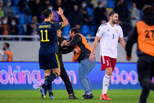 A pitch invader next to Zlatan Ibrahimovic of Sweden