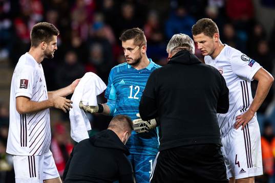 Goalkeeper Roberts Ozols of Latvia receives medical
