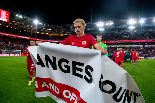 Morten Thorsby of Norway holds a banner with the text "Make