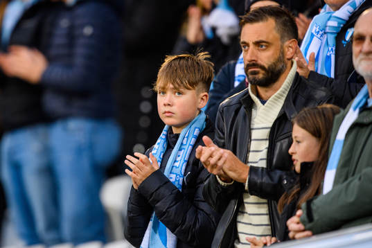 En ung pojke med Malmö FFs halsduk på läktaren