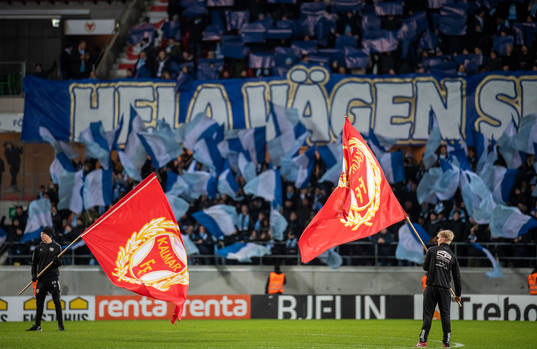 Kalmarflaggor mot en fond av Malmö FFs tifo