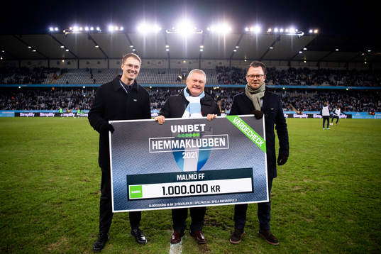 Malmö FFs ordförande Anders Pålsson tar emot en check