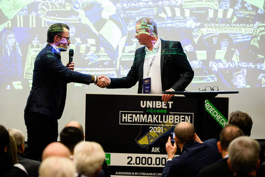 AIK Fotbolls ordförande Robert Falck tar emot en check