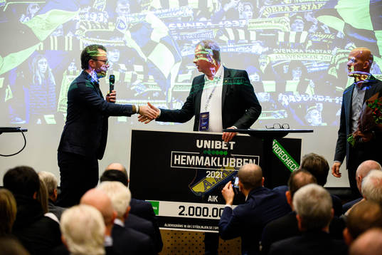 AIK Fotbolls ordförande Robert Falck tar emot en check