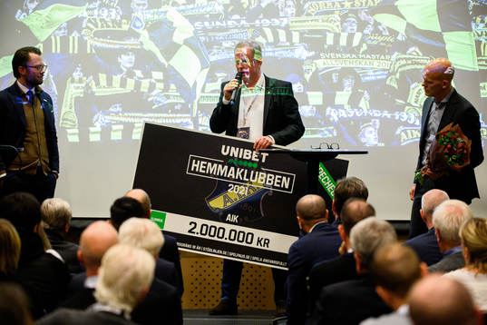 AIK Fotbolls ordförande Robert Falck tar emot en check