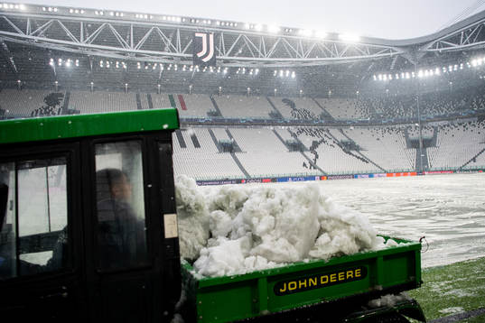 Workers clear the pitch from snow at Allianz Stadium