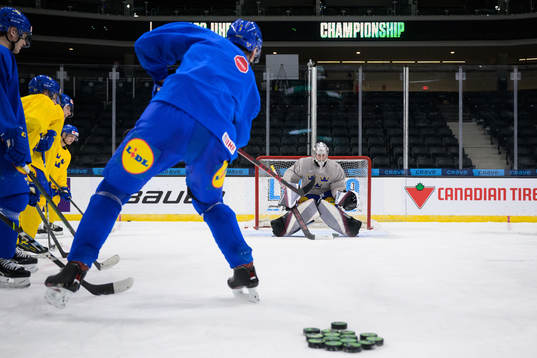 Helge Grans shoots against goaltender Jesper Vikman of the