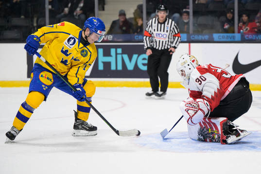 William Eklund of Sweden challenges goaltender Sebastian