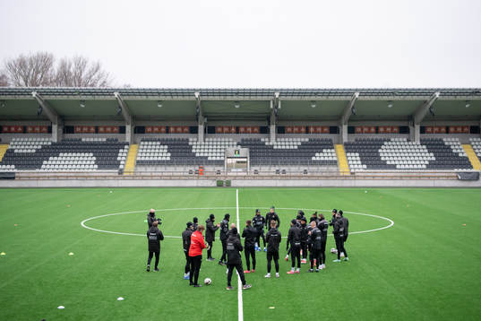 Spelarna samlas på planen innan en träning med det