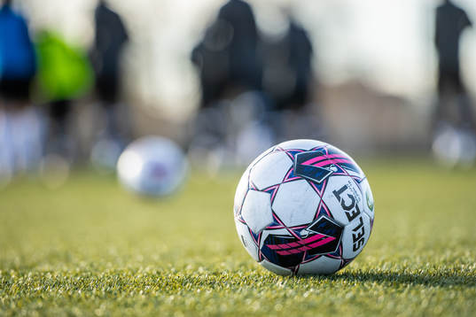 En fotboll ligger på fotbollsplanen