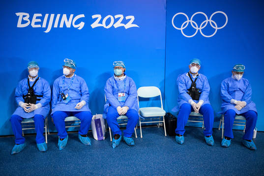 Medical personel in personal protective gear watch the