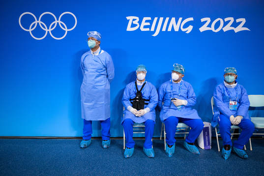 Medical personel in personal protective gear watch the