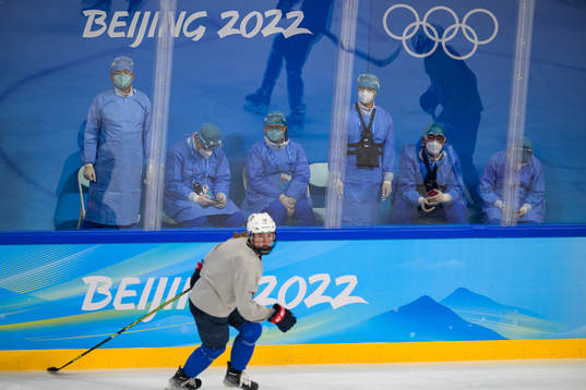 Medical personel in personal protective gear watch the