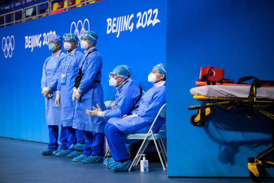 Medical personel in personal protective gear watch the