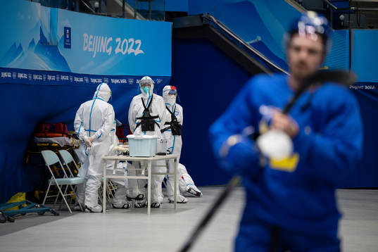 Workers in full-body protective gear (PPE) and Anton Lander