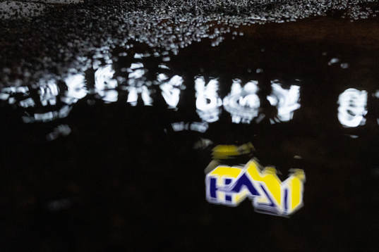 s logotyp speglas i en vattenpöl