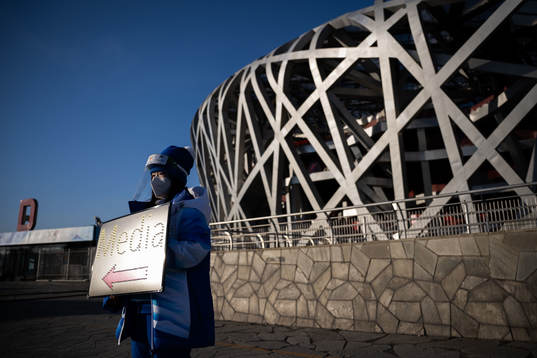 A volunteer in front of the National Stadium, also known as