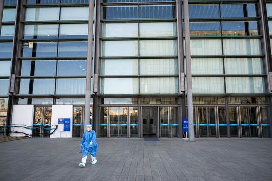 A worker in protective gear outside National Indoor Stadium