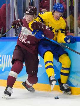 Kristaps Zile of Latvia tackles Fredrik Olofsson of Sweden