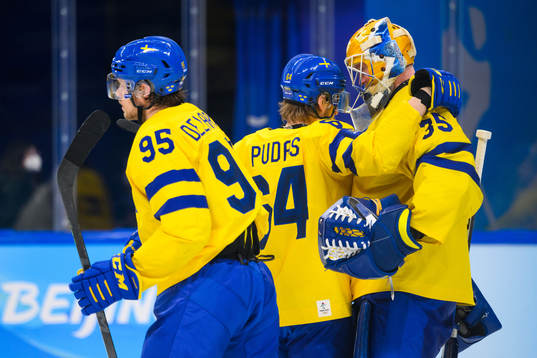 Jonathan Pudas and goaltender Magnus Hellberg of Sweden