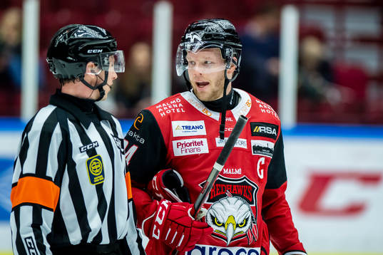 Domare Christoffer Holm samspråk med Malmö Redhawks Carl