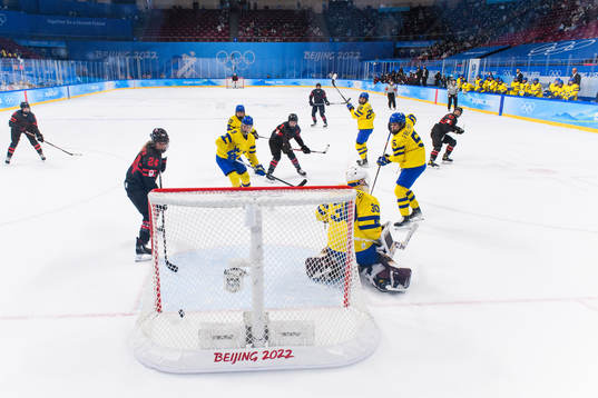 Natalie Spooner of Canada scores a goal behind goaltender