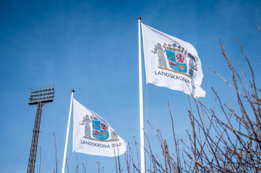 Två flaggor med Landskrona Stads logotype på