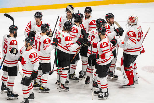Players of Canada celebrate with goaltender Matt Tomkins in
