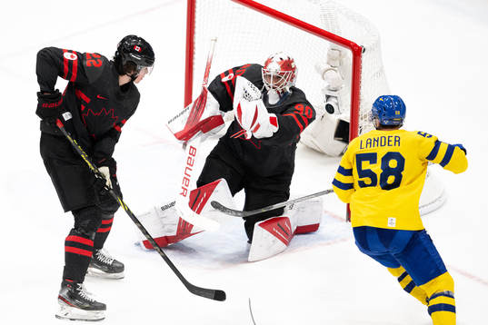 Anton Lander of Sweden against Owen Power and goaltender