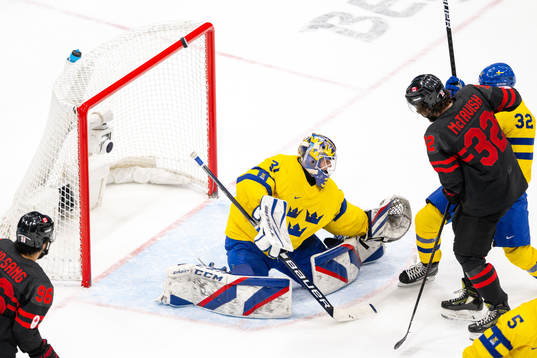 Mason Mctavish of Canada against goaltender Lars Johansson