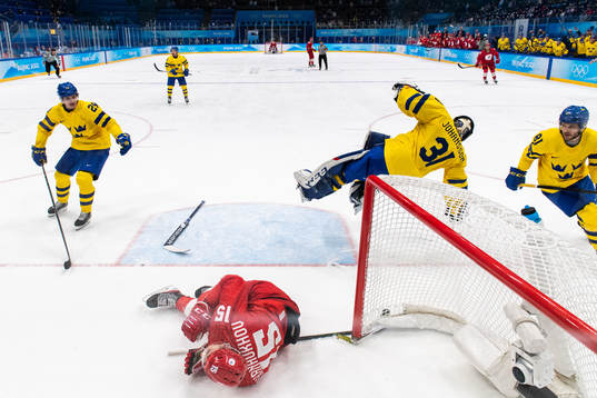 Pavel Karnaukhov of Russia in a collision with goaltender