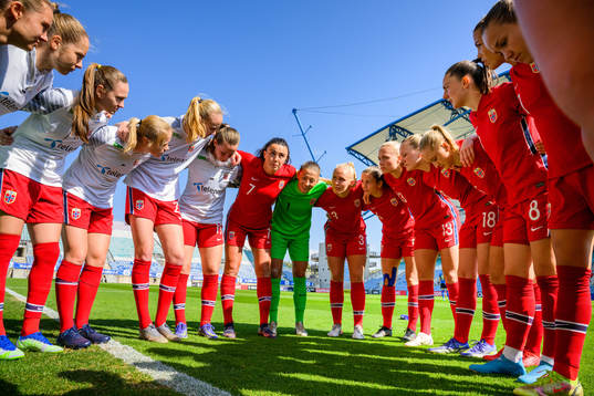Players gather around Ingrid Syrstad Engen of Norway