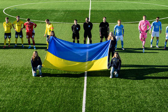 Funktionärer håller upp en Ukrainsk flagga
