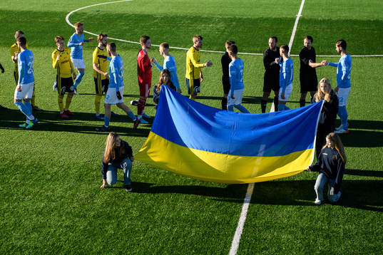 Funktionärer håller upp en Ukrainsk flagga