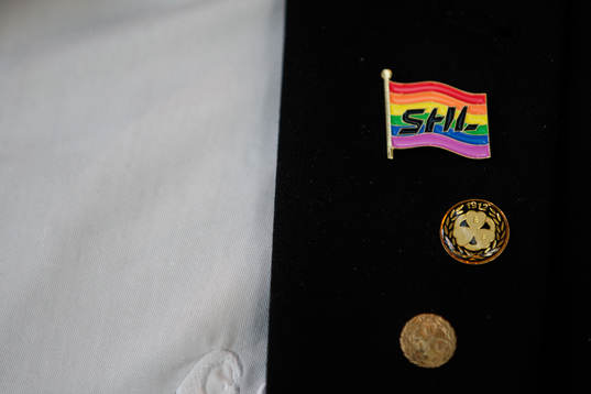 En SHL-flagga i regnbågsfärger på en funktionär
