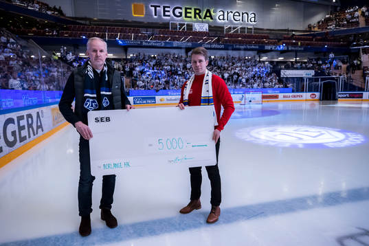 Hans Larsson från SEB delar ut ut check till Erik
