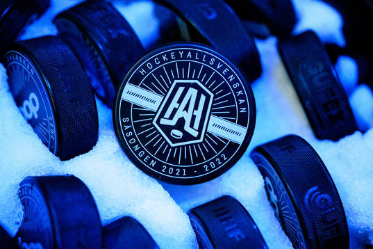 En puck med logotypen för Hockeyallsvenskan i en ishink