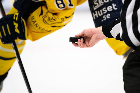 En domare håller i en puck