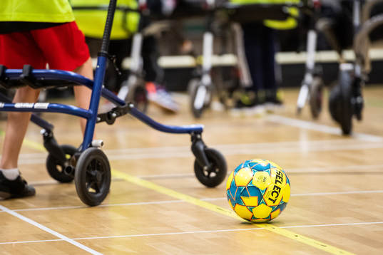 Frame-fotbollsspelare med en boll i förgrunden