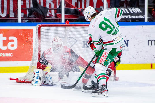Rögles Adam Tambellini framför Malmö Redhawks målvakt