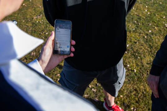 Tim Nielsen håller i en mobiltelefon med Torn IFs